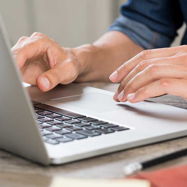 Man typing on laptop about Oracle Cloud at Customer